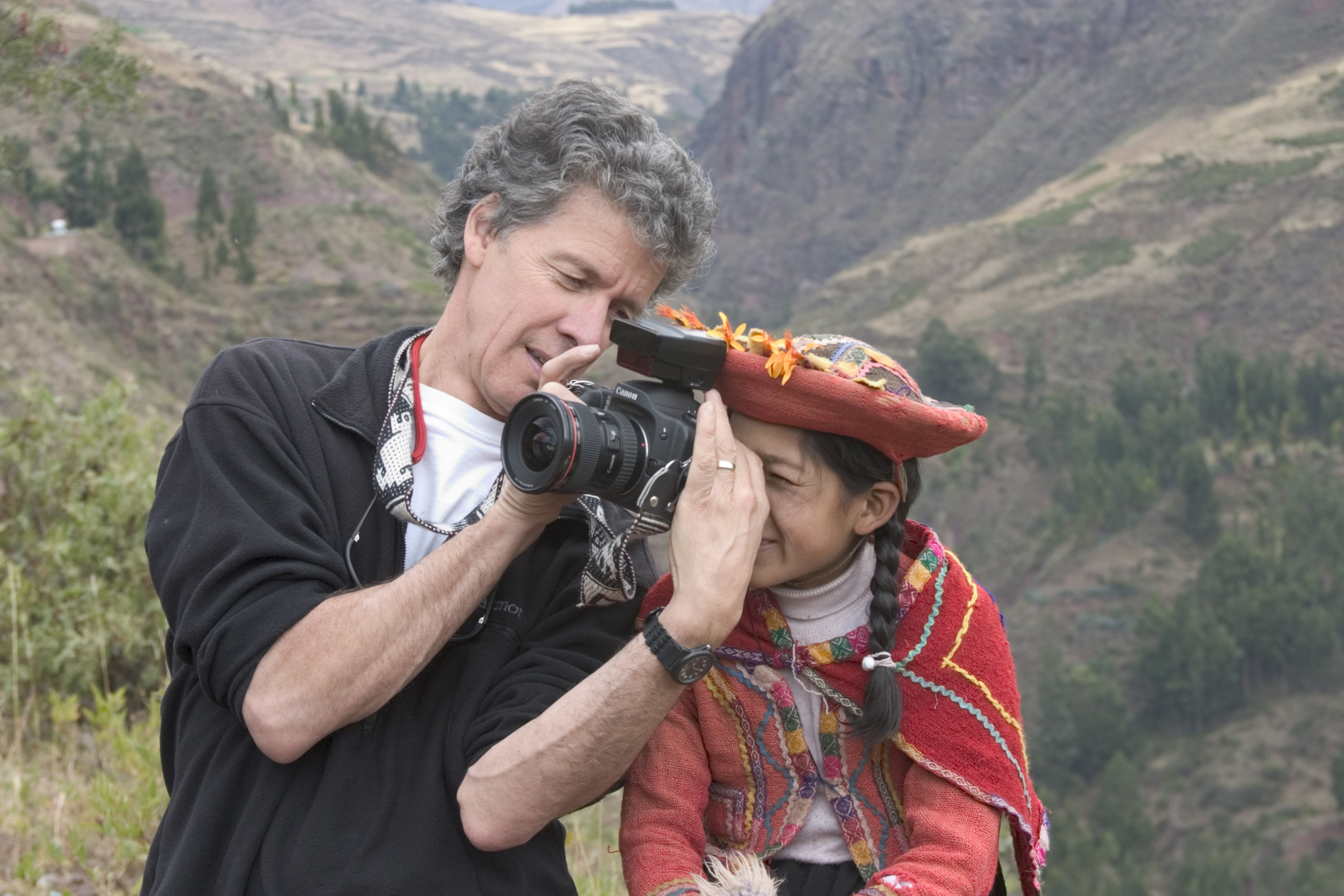 FRIENDSHIP THROUGH A DIFFERENT LENS: Bridges founder and internationally acclaimed photographer Phil Borges working with a Peruvian youth during an international workshop.